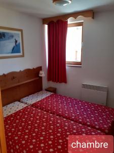a bedroom with a bed with a red blanket and a window at Les Villages du Bachat à Chamrousse 1700 - Droseras D12 Classé 3 étoiles in Chamrousse +10 photos