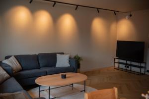 a living room with a couch and a table at Penthouse, heart of city center, high standard in Stavanger