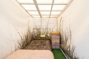 a room with a bed and a dresser and grass at Garden Clamping in Tallinn