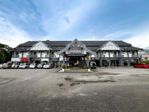 a large building with cars parked in a parking lot at Sarina Hotel, Jeli in Jeli