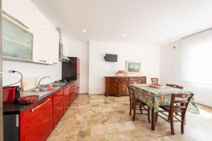 a kitchen with a table and a dining room at Residence Anna - Red Apartment in Roseto degli Abruzzi