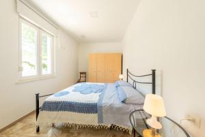 a white bedroom with a bed and a window at Residence Anna - Red Apartment in Roseto degli Abruzzi