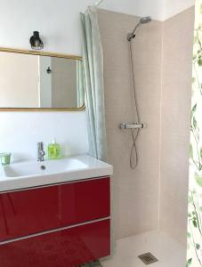 Un baño con un lavabo rojo y una ducha. en Casa Rural Miraelrio, en Corral Rubio