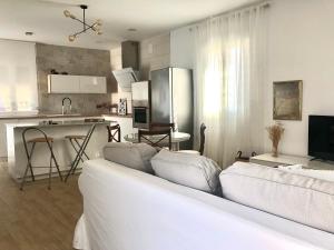 Una sala de estar con un sofá blanco y una cocina. en Casa Rural Miraelrio, en Corral Rubio 20 fotos más