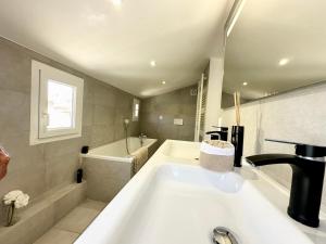 a bathroom with a bath tub and a sink at GORGEOUS BRAND NEW 2 BEDROOMS in Antibes +11 photos