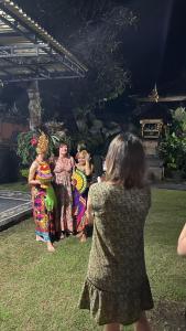 a woman taking a picture of a group of women at Tamansari Homestay in Sawan