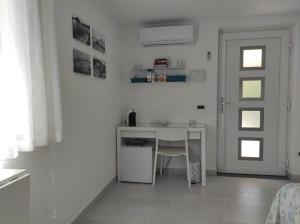a white kitchen with a table and a door at Il Leccio in Ischia Town