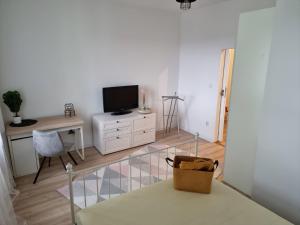 sala de estar con TV y escritorio con silla en Apartament GABI, en Świdnica