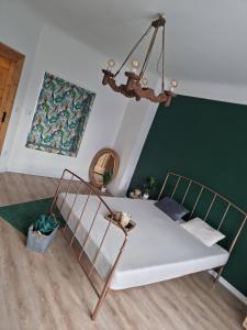 Cama en habitación con pared verde en Apartament GABI, en Świdnica