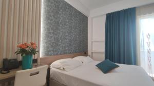 a bedroom with a bed and a vase of flowers at Hotel Maiuri Pompei in Pompei