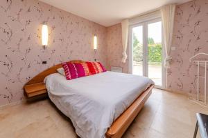 a bedroom with a bed with red pillows and a window at La maison de Gradille - Piscine in Lisle-sur-Tarn +47 photos