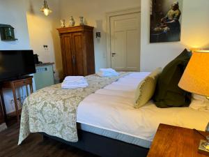 a bedroom with a bed with towels on it at Hofstede de Rieke Smit in Wilsum