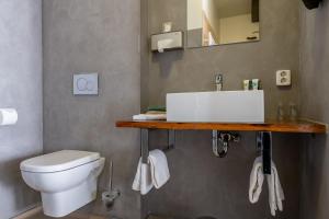 a bathroom with a white sink and a toilet at Boutique Hotel De Eilanden in Harlingen +37 photos