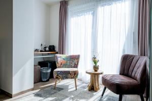 a living room with a chair and a chair at Boutique Hotel De Eilanden in Harlingen