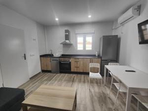 a kitchen with a table and a stove top oven at Apartamentos Bolonia - M a n u e l a in Bolonia
