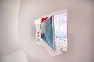 um quarto com um espelho numa parede branca em Honeymoon Ruterra studio em Praga