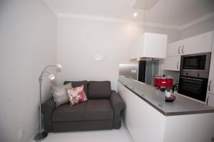 uma pequena sala de estar com um sofá na cozinha em Honeymoon Ruterra studio em Praga
