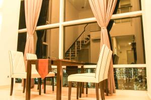 mesa de comedor con 2 sillas blancas y mesa con mesa en Premier Suite at Maritime en George Town