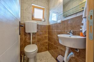 a bathroom with a toilet and a sink at Family 4M in Zlatibor +11 photos
