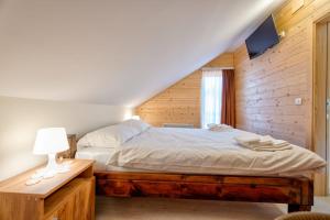 a bedroom with a bed in a wooden wall at Family 4M in Zlatibor