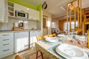 a kitchen with a table with plates and wine glasses at Family 4M in Zlatibor