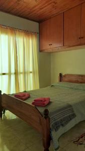 a bedroom with a wooden bed and a window at Hospedaje Navarro Dpto N3 matrimonial in Navarro