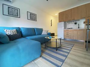 un soggiorno con un divano blu e un tavolo di Apartman Peric a Ruma