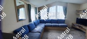 a living room with a blue couch and a tv at Astral 138 snowdon summit 098 in Barmouth