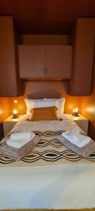 ein großes Bett mit zwei Kissen und zwei Lampen darauf in der Unterkunft Limiria Studio in Santa-Maria-Poggio