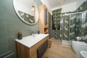 un bagno con lavandino e specchio di Vesuvius Apartament a Scafati