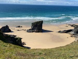 a beach with two large rocks in the sand at The Stables at Hustyn Gate in Wadebridge