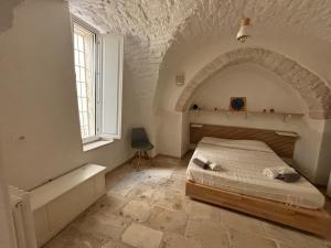 a bedroom with a bed and a window and a tub at Casa Nené in Cisternino