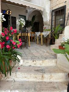 Un patio con mesa y sillas y flores. en Casa Nené, en Cisternino 7 fotos más