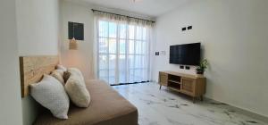 a living room with a couch and a flat screen tv at Casa Ecos d' Alma in Isla Mujeres