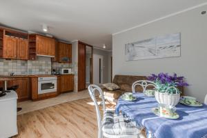 a kitchen and living room with a table with a blue table cloth at Ustka Apartament Na Wydmie 4 in Ustka +5 photos