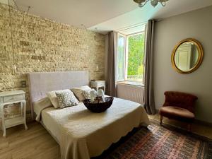 une chambre avec un lit, une chaise et un miroir dans l'établissement Domaine Borgnat, à Escolives-Sainte-Camille