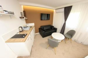 a small kitchen with a table and a chair and a table and a couch at Apartman LIKE Sarajevo 2 in Sarajevo