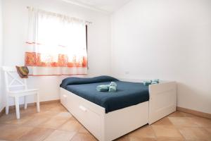 a bedroom with a bed with blue sheets and a window at Casina Maria in Murta Maria