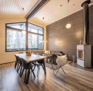 a living room with a table and chairs and a fireplace at Rukanmetsä, cottage, Ruka in Rukatunturi  +23 photos