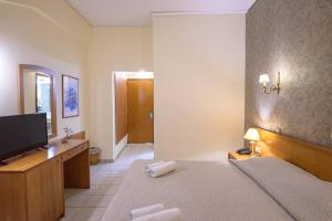 a bedroom with a bed and a flat screen tv at Neda Hotel in Olympia