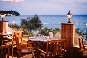 a table and chairs with a view of the ocean at Grand Hotel Des Sablettes Plage, Curio Collection By Hilton in La Seyne-sur-Mer