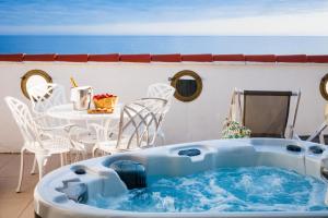 a hot tub on a patio with a table and chairs at Grand Hotel Des Sablettes Plage, Curio Collection By Hilton in La Seyne-sur-Mer