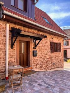 a wooden table in front of a brick building at La Mignardise du Château in Lichtenberg