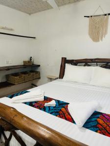 una camera da letto con un letto con asciugamani sopra di Savita House Diani a Magutu