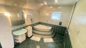 a bathroom with a tub and a sink and a toilet at Zöldház in Balatonmáriafürdő +45 photos