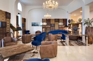 a room with chairs and tables and a chandelier at Grand Hotel Des Sablettes Plage, Curio Collection By Hilton in La Seyne-sur-Mer