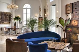 a living room with a blue couch and a table at Grand Hotel Des Sablettes Plage, Curio Collection By Hilton in La Seyne-sur-Mer