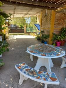 two picnic tables with mosaics on them in a patio at El Cumpa Bungalow in La Paz