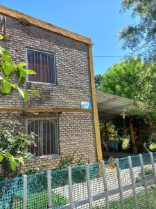a brick house with a fence in front of it at El Cumpa Bungalow in La Paz