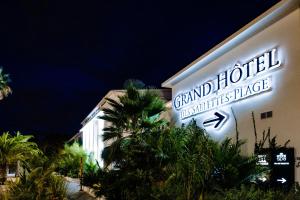 a building with a sign that reads grand floridian psychiatrist place at Grand Hotel Des Sablettes Plage, Curio Collection By Hilton in La Seyne-sur-Mer